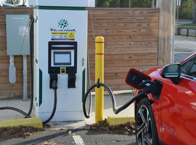 A red car is parked at a gas station